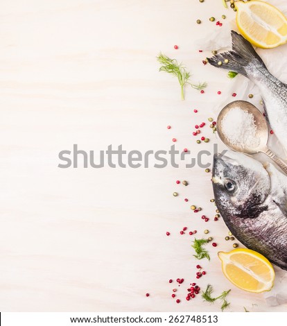 Raw  dorado fish with multicolor pepper,lemon an spoon of salt on white wooden background, top view, place for text