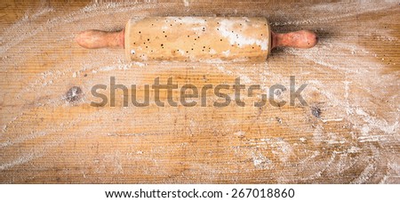Rolling pin on old wooden background with  wheat flour, banner for website , top view