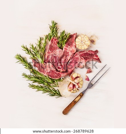 Raw meat  lamb loin chops with meat fork herb and spices on white wooden background, top view