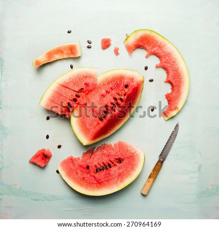 watermelon slices with knife on blue wooden background, top view
