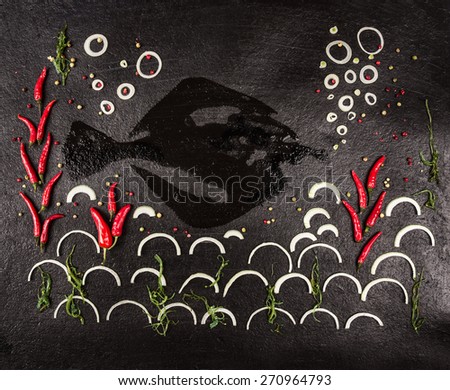 Composition of herbs, spices and fish shape with sea and coral made by onion,chili and algae on dark stone background