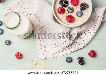 oatmeal porridge with milk and berries on kitchen towel, top view