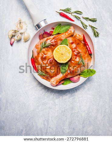 raw chicken legs with red spicy sauce and herbs ,  preparation for cooking, top view