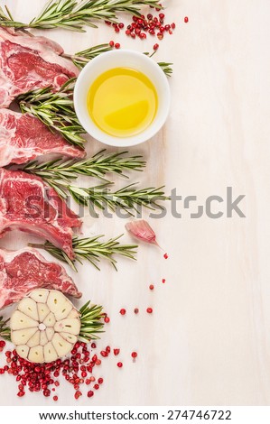 Raw  lamb chops with oil and spices, preparation on white wooden background, frame, place for text