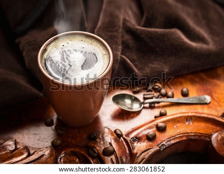 Cup of black coffee in morning light on rustic table