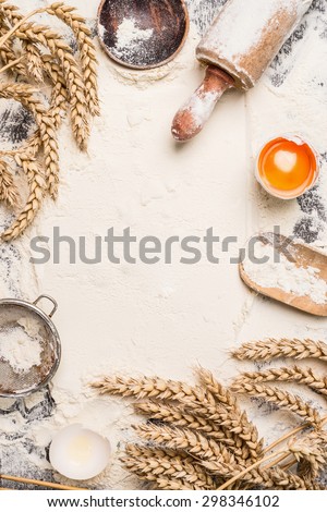 flour baking background with raw egg, rolling pin and wheat ear , top view