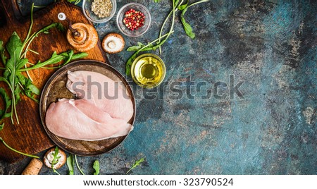 Raw Chicken breast and fresh ingredients for cooking on blue rustic background, top view, banner. Healthy, diet food or Sports nutrition concept.