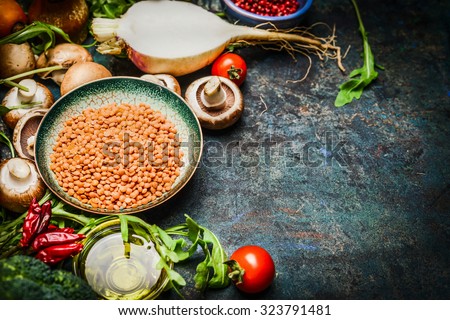 Lentil with fresh vegetables and ingredients for cooking on blue rustic background, close up. Vegan food , vegetarian , diet or  healthily cooking concept.