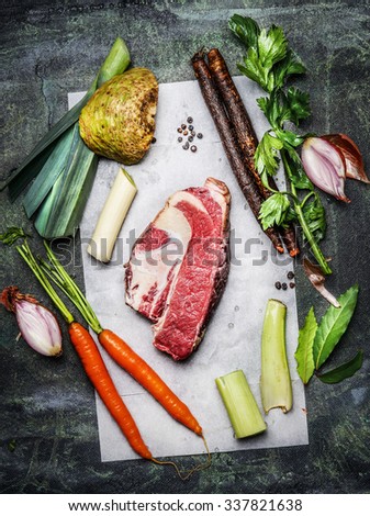 Raw beef brisket meat with organic vegetables ingredients for soup or broth cooking on rustic background, top view.