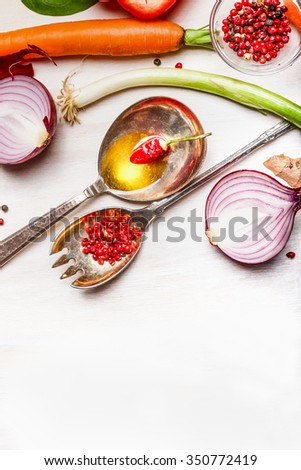 Spoons with oil and spices and vegetables ingredients for healthy cooking on white wooden background, top view, close up