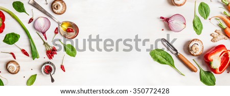 Healthy food background with various vegetables ingredients, spoon with oil and peeler, top view