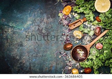 Fresh vegetables cooking ingredients with kale , lemon and tomatoes on rustic background, top view, border. Healthy food or diet nutrition concept