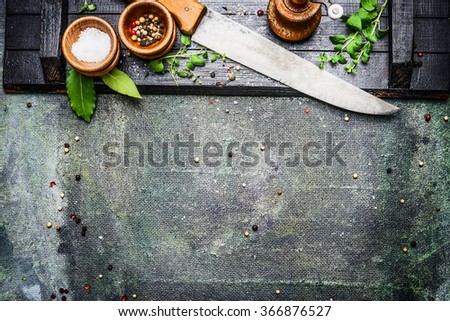 Cooking set with Kitchen knife with table spices, salt and pepper mills on rustic background , top view, place for text