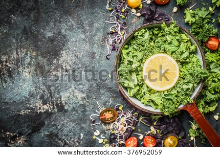 Fresh kale leaves with lemon and ingredients in old cooking pot on rustic background, top view, place for text.  Healthy lifestyle or detox  diet food concept.