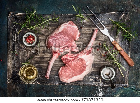 Raw pork cutlet with oil and spices for grill or cooking on rustic background, top view.  Porco Iberico French Racks.