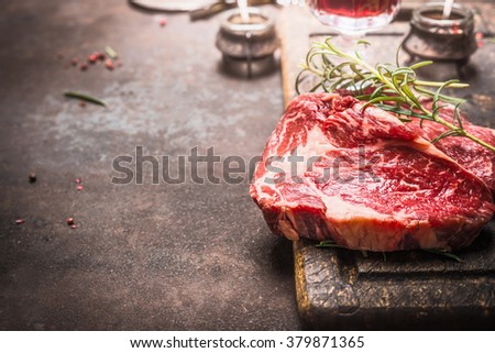 Close up of raw fresh meat Ribeye Steak with herbs and spices on dark rustic metal background, place for text.