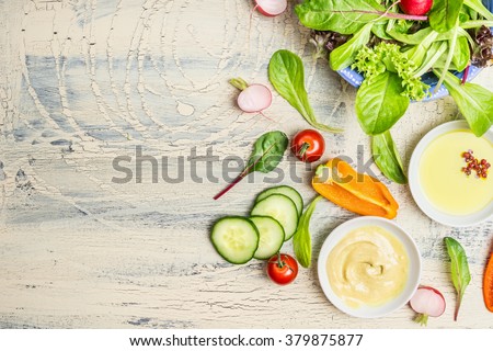 Fresh organic green salad preparation with oil and  dressing ingredients on light rustic background, top view, place for text. Healthy lifestyle or detox diet food concept