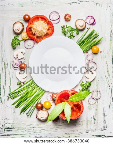 Various vegetables and seasoning cooking  ingredients around blank plate on light  rustic wooden background, top view composing. Healthy eating and diet food concept.