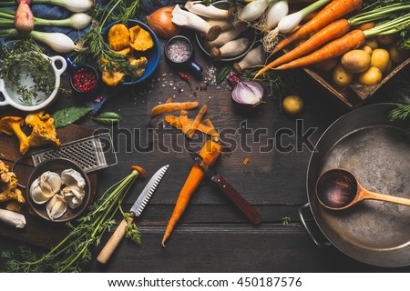 Cooking with forest mushrooms and  vegetables ingredients and kitchen tools, preparation on dark rustic wooden table, top view