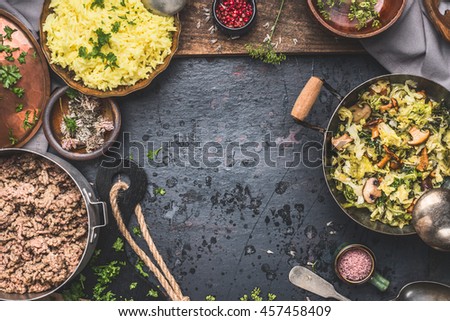 Delicious dish with  stewed chopped cabbage and mushrooms, yellow rice and mincemeat on dark background , top view. Rustic food cooking