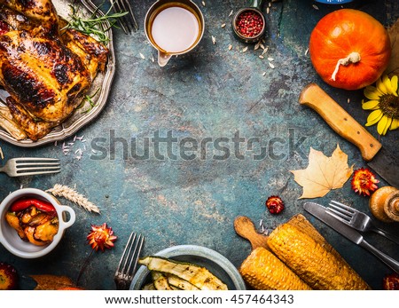 Roasted whole chicken or turkey with sauce and grilled autumn vegetables: corn,pumpkin ,paprika on dark rustic background, top view, frame. Thanksgiving Day food concept