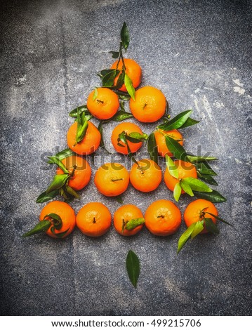 Christmas tree make with tangerines on dark rustic background, top view, festive greeting card