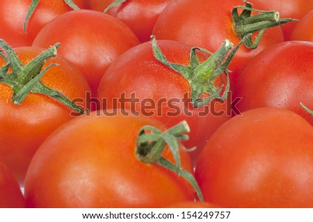 Contiguous background texture of red juicy fresh tomatoes in close up