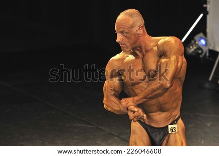 ROOSENDAAL, THE NETHERLANDS - OCTOBER 19, 2014. Male bodybuilder showing his muscular back at a bodybuilding and fitness contest.