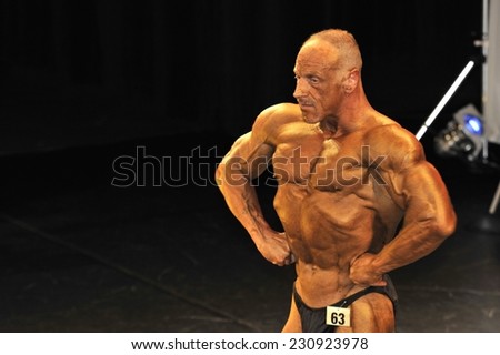 ROOSENDAAL, THE NETHERLANDS - OCTOBER 19, 2014. Male bodybuilder showing his chest pose at the bodybuilding and fitness contest at the Walter\'s Open Dutch Championship Bodybuilding and Fitness.