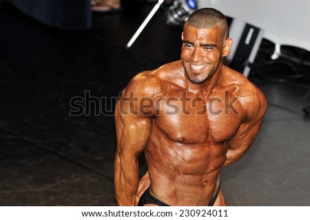 ROOSENDAAL, THE NETHERLANDS - OCTOBER 19, 2014. Male bodybuilder showing his triceps pose at the bodybuilding and fitness contest at the Walter\'s Open Dutch Championship Bodybuilding and Fitness.