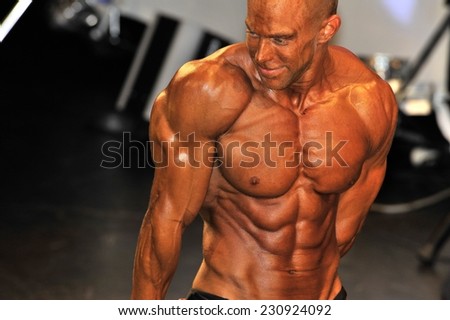 ROOSENDAAL, THE NETHERLANDS - OCTOBER 19, 2014. Male bodybuilder showing his triceps pose at the bodybuilding and fitness contest at the Walter\'s Open Dutch Championship Bodybuilding and Fitness,