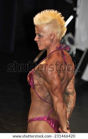 ROOSENDAAL, THE NETHERLANDS - OCTOBER 19, 2014. Female bodybuilding contestant Cindy Limpens showing her triceps pose at the Walter\'s Open Dutch Championship Bodybuilding and Fitness