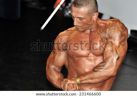 ROOSENDAAL, THE NETHERLANDS - OCTOBER 19, 2014. Male bodybuilder showing his chest and biceps pose at the Walter\'s Open Dutch Championship Bodybuilding and Fitness.