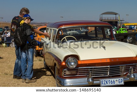 PRETORIA, SOUTH AFRICA - AUGUST 4:  An unknown man and boy admiring a 1957 Ford station wagon at Cars in the Park - South Africa\'s biggest vintage car show - on August 4, 2013 in Pretoria.