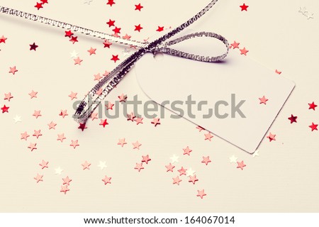 White background with silver and red stars paperboard card to ender text