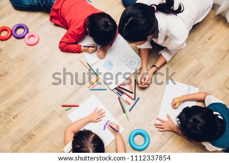 Family happy children group kid boy and girl kindergarten paint drawing on peper teacher education at interior playroom, back to school concept
