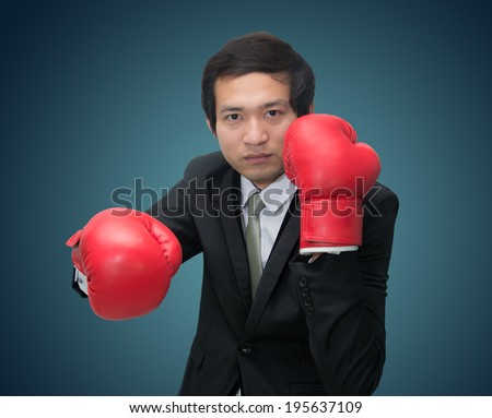 Businessman unusual standing posture in boxing gloves isolated on over blue background