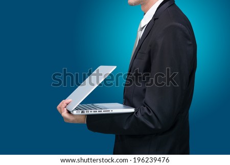 Businessman standing posture hand hold notebook laptop isolated on blue background
