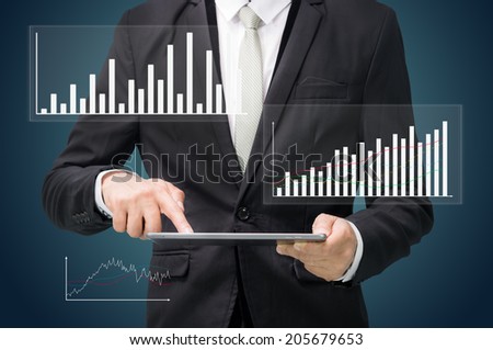 Businessman standing posture hand hold graph on tablet isolated on dark background