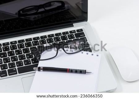 Blank business laptop, mouse, pen, glasses and note on white table