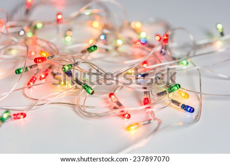 Closeup of Christmas lights on white table background