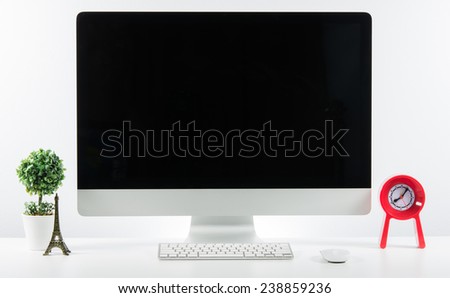 Business place of work with with computer monitor keyboard and accessories on table on white wall