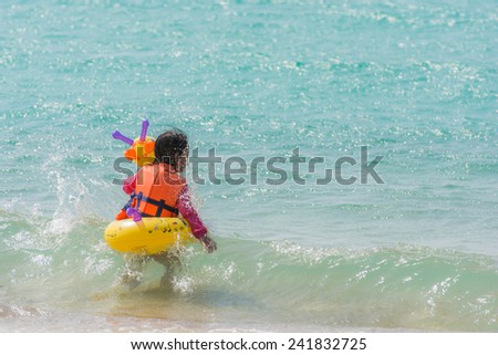 kid girl enjoying swimming in sea with rubber ring giraffe, Not seen face