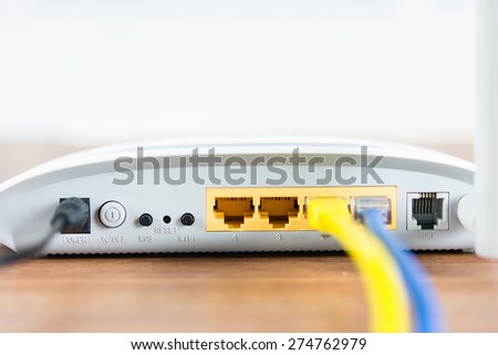 Wireless modem router network hub with cable connect on wooden table in the room