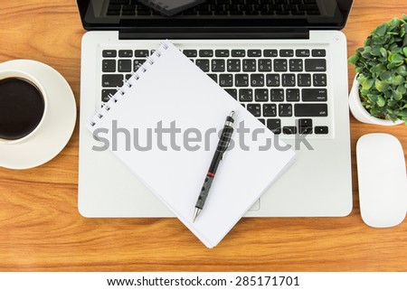 Notebook laptop and coffee cup on wood table