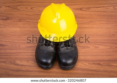 Top view safety shoes and composition of working tools on wooden table
