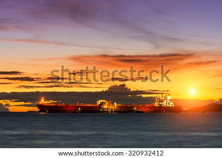 Oil Tanker loading oil in the sea with sunset
