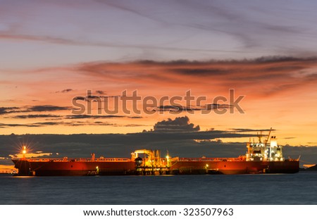 Oil Tanker loading oil in the sea with sunset