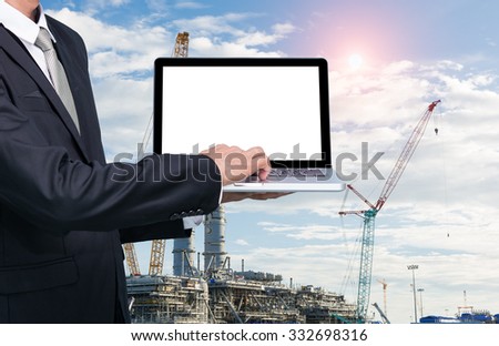 Engineering working hold conputer notebook in front of construction supervisor site