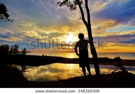 Silhouette of male watching the sunset over Lake Huron. Port Crescent State Park. Port Austin, Michigan.